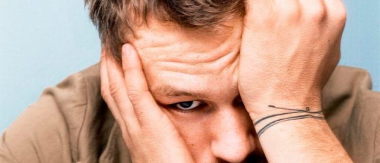 Держится за голову и зажимает глаза